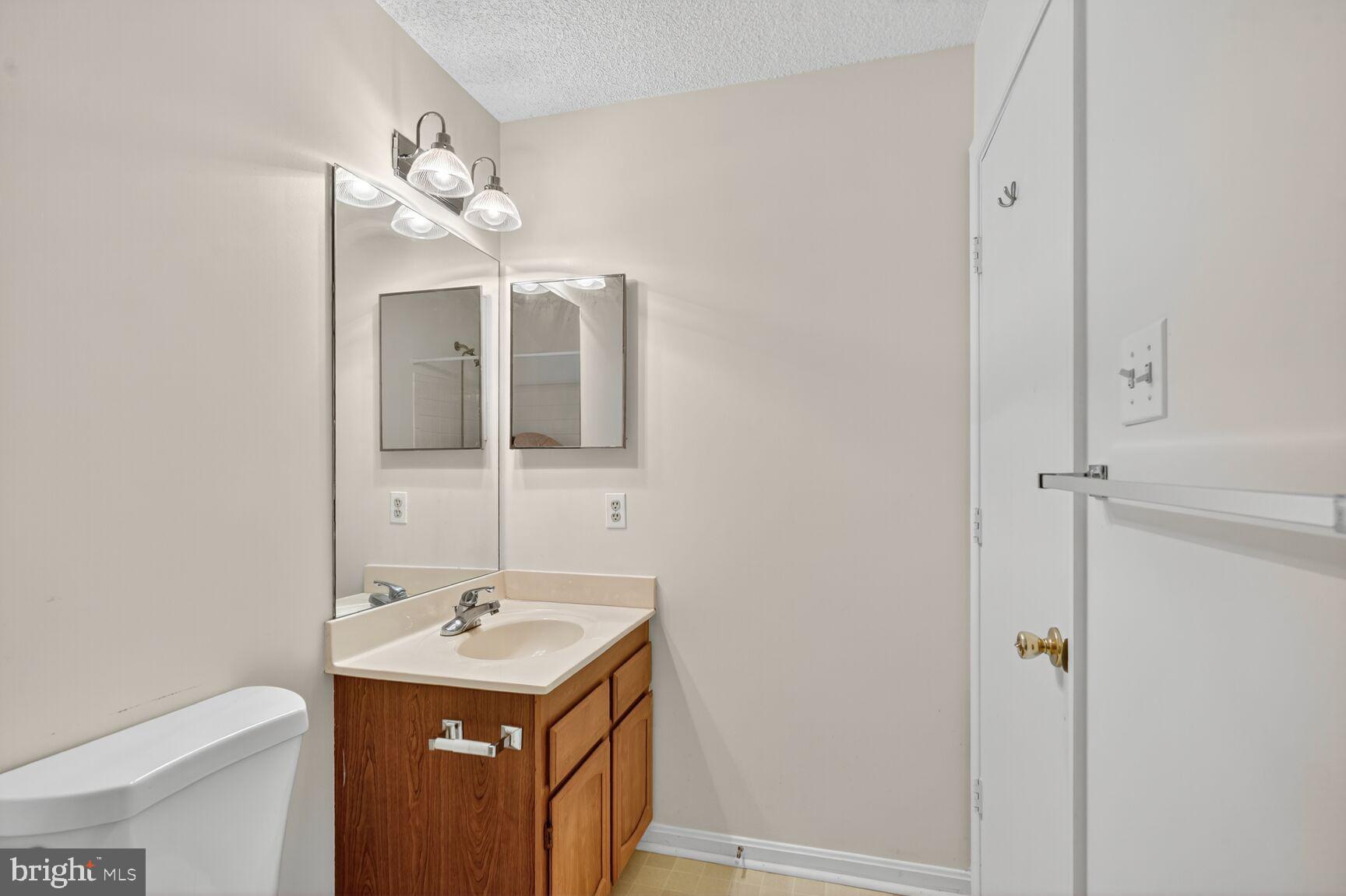 14101 Valleyfield Drive, Unit 114 Silver Spring, MD 20906 - Photo 12 of 26 a bathroom with a sink a mirror and a toilet