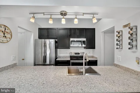 a kitchen with stainless steel appliances a refrigerator and a stove