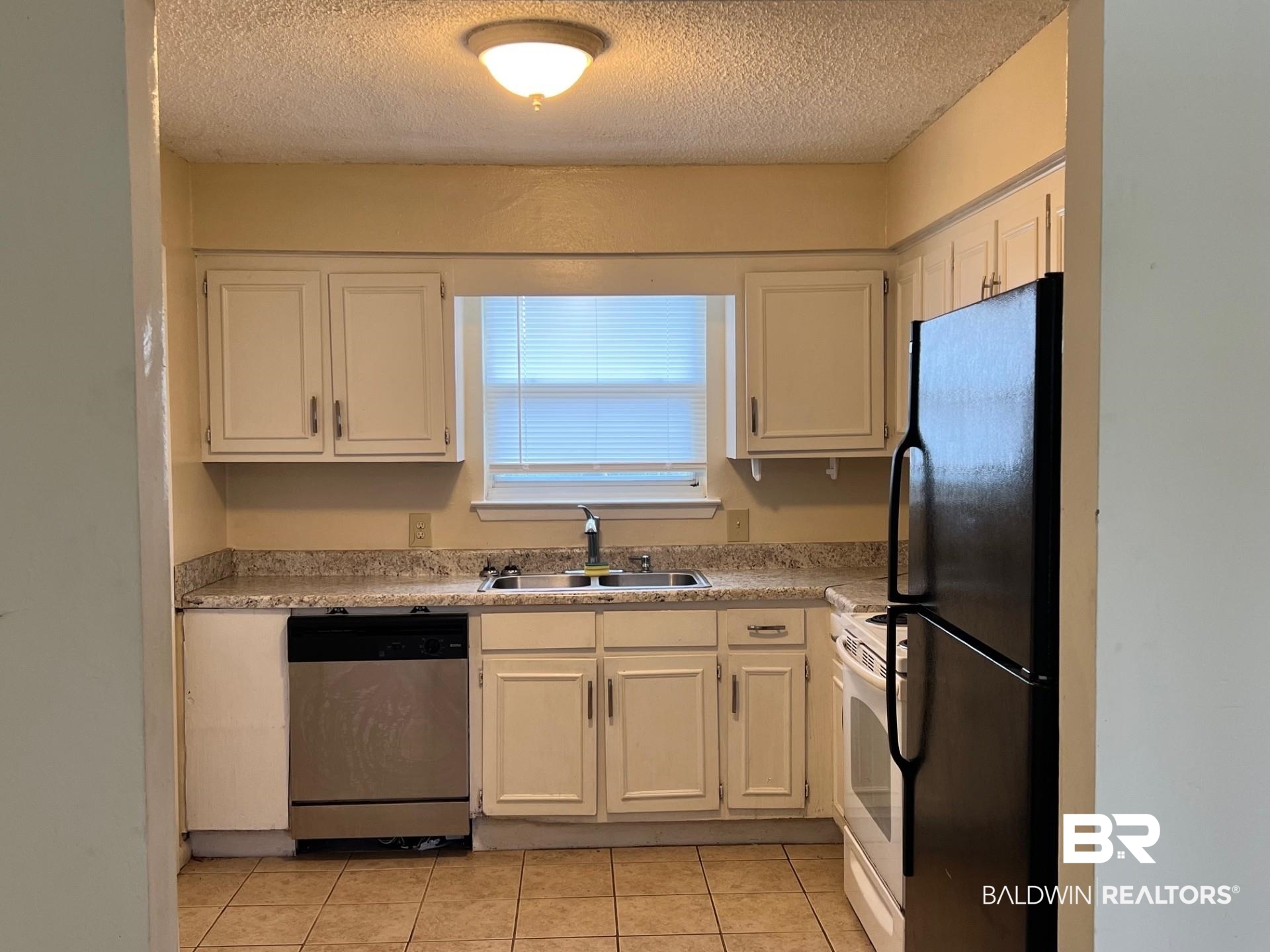 72 Grimes Lane Loxley, AL 36551 - Photo 5 of 12 Kitchen with light countertops, freestanding refrigerator, dishwasher, white cabinets, and a textured ceiling