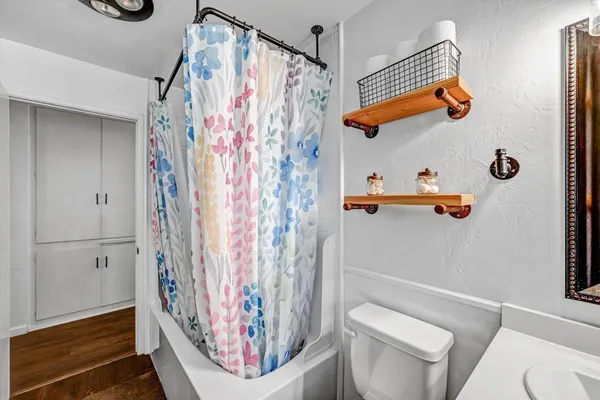 a bathroom with a toilet and shower curtain