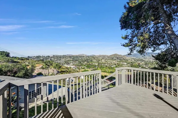 a view of a balcony with wooden fence and floor