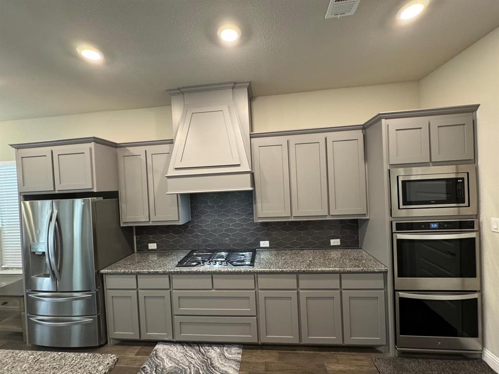 1204 Sundrop Drive Little Elm, TX 75068 - Photo 5 of 24 a kitchen with stainless steel appliances granite countertop a refrigerator a stove and a sink