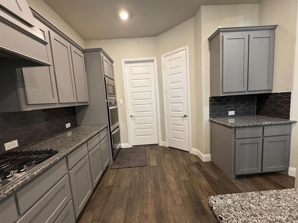 1204 Sundrop Drive Little Elm, TX 75068 - Photo 7 of 24 a kitchen with granite countertop a sink cabinets and stainless steel appliances