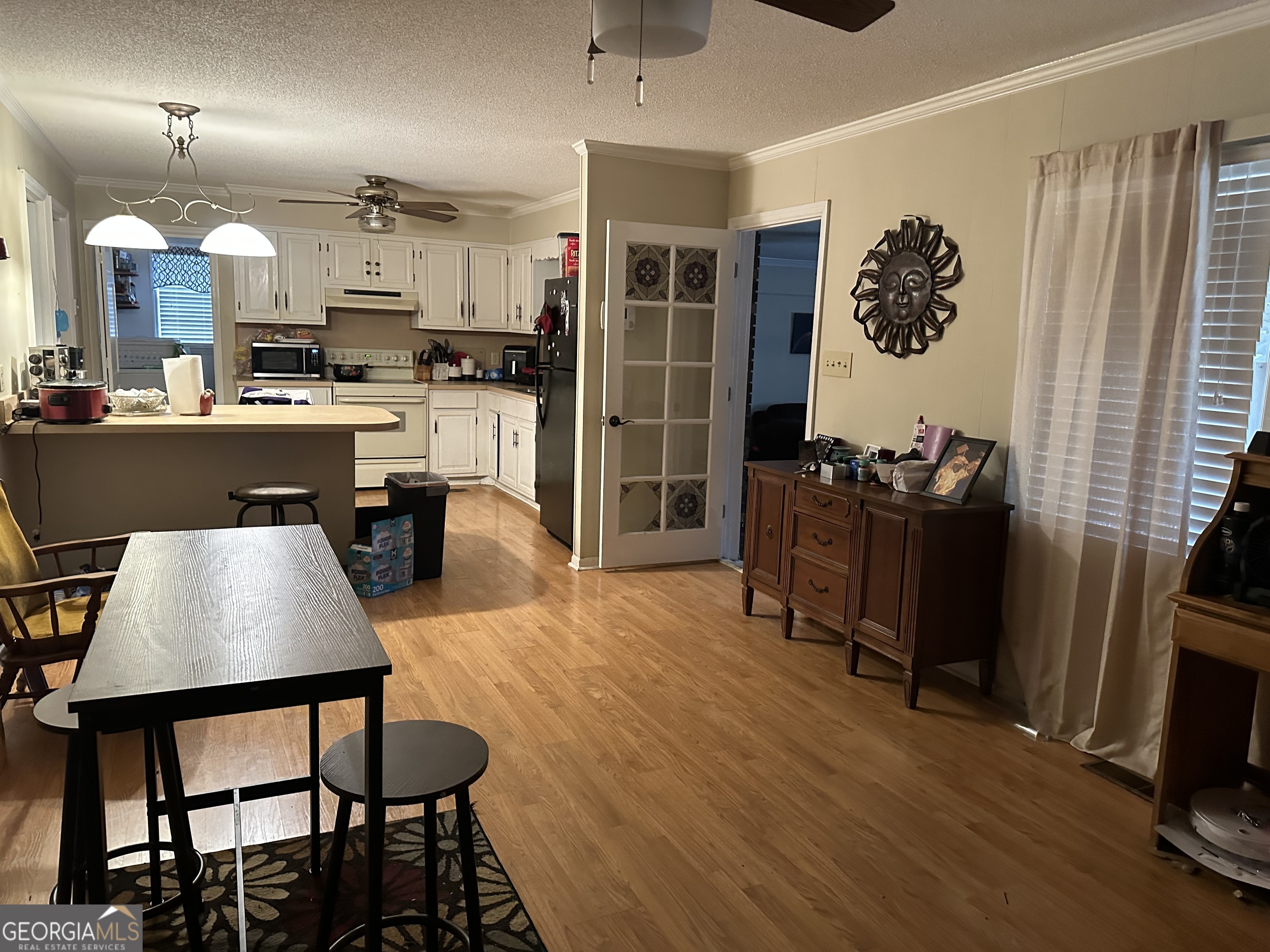 1537 Webb Street Albany, GA 31721 - Photo 12 of 15 a kitchen with stainless steel appliances granite countertop a refrigerator a stove top oven and a dining table with wooden floor