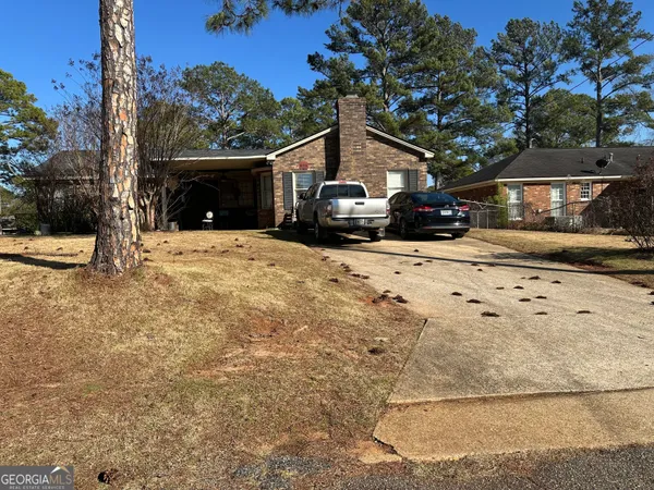 a front view of a house with a yard covered with snow