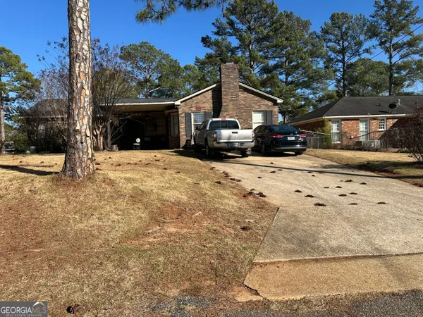a front view of a house with a yard covered with snow
