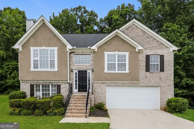 a front view of a house with a yard and garage