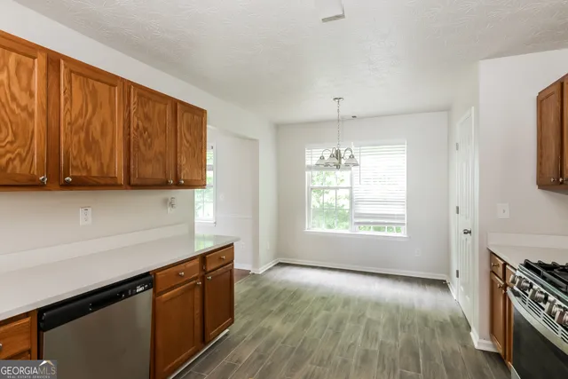 a kitchen with granite countertop wooden cabinets a stove a sink and a window