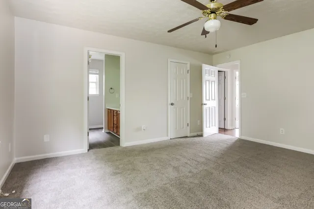 an empty room with closet and a chandelier fan