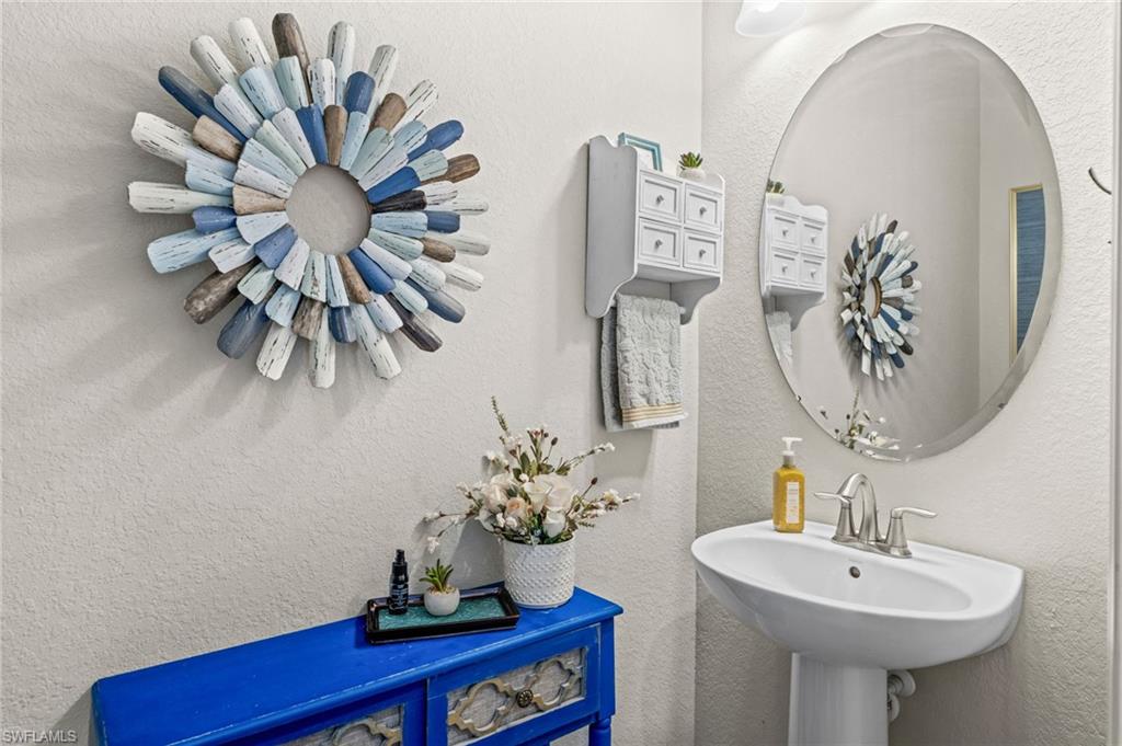 4754 Abaca Circle Naples, FL 34119 - Photo 15 of 46 a bathroom with a sink a mirror and a potted plant