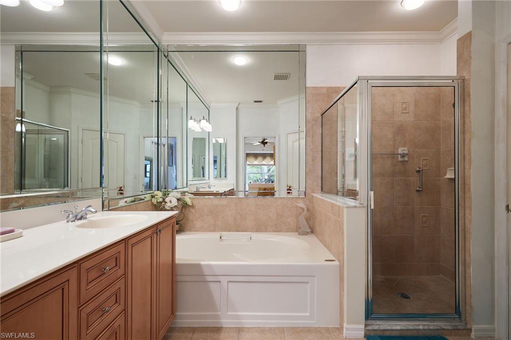 20540 Rookery Drive Estero, FL 33928 - Photo 19 of 32 a en suite bathroom with a granite countertop sink a mirror and shower