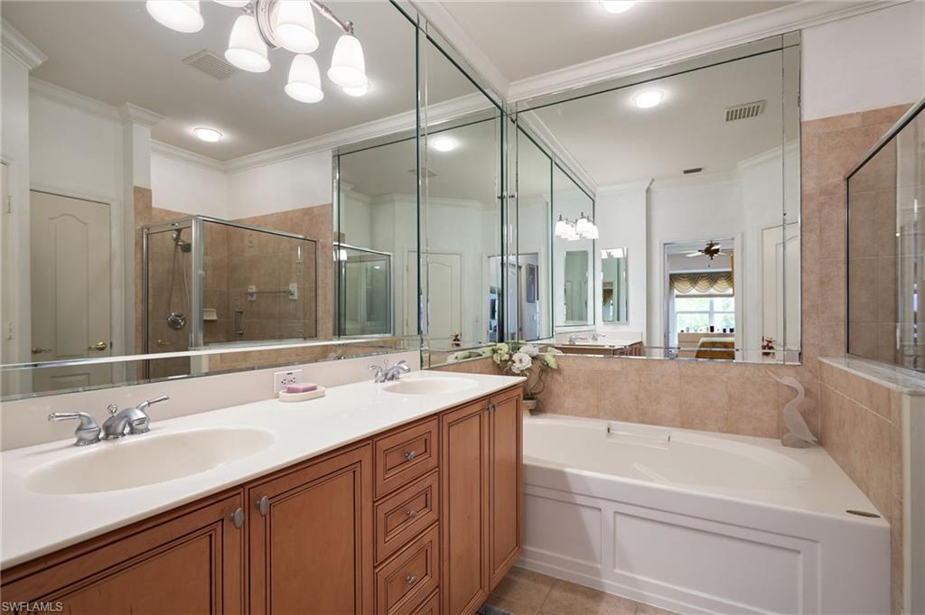 20540 Rookery Drive Estero, FL 33928 - Photo 20 of 32 a bathroom with a tub a sink double vanity and a large mirror