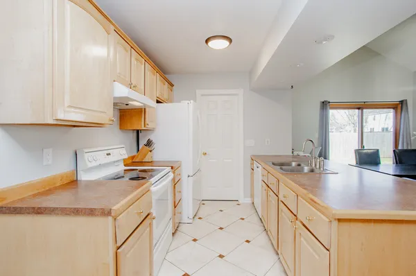 a kitchen with granite countertop a sink a stove and cabinets