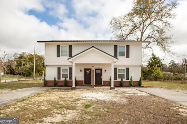 a view of a house with backyard and trees