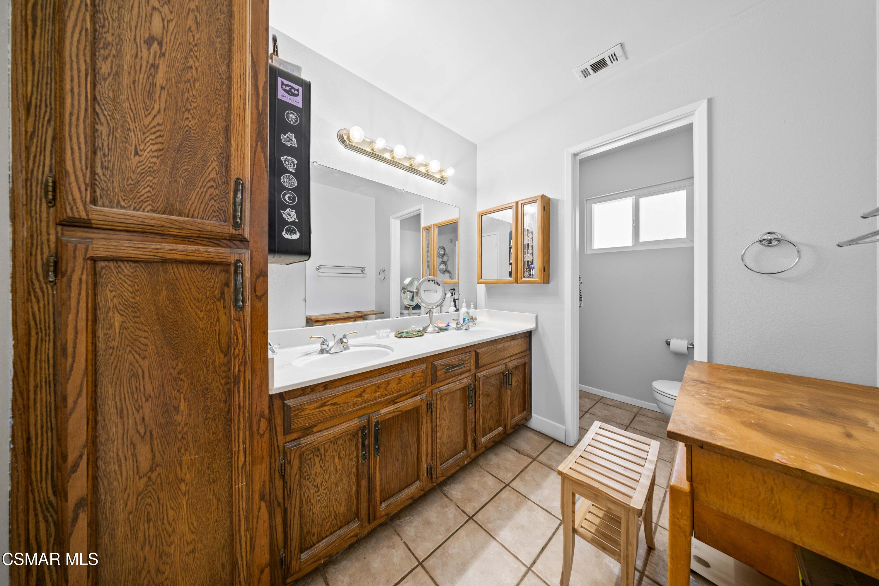 4931 Roundup Road Norco, CA 92860 - Photo 12 of 21 a spacious bathroom with a double vanity sink and a mirror