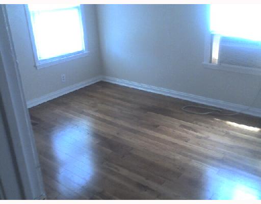 825 Indiana Avenue, Unit 2 Corpus Christi, TX 78404 - Photo 4 of 5 an empty room with wooden floor and windows