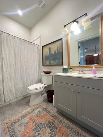 a kitchen with granite countertop a refrigerator a sink a stove and white cabinets