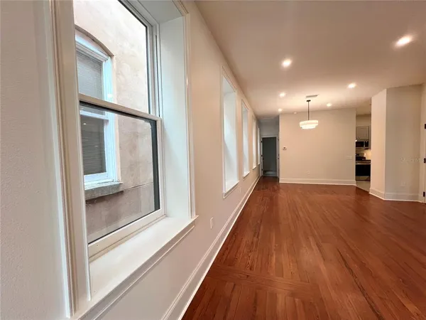 a view of a big room with windows and chandelier fan