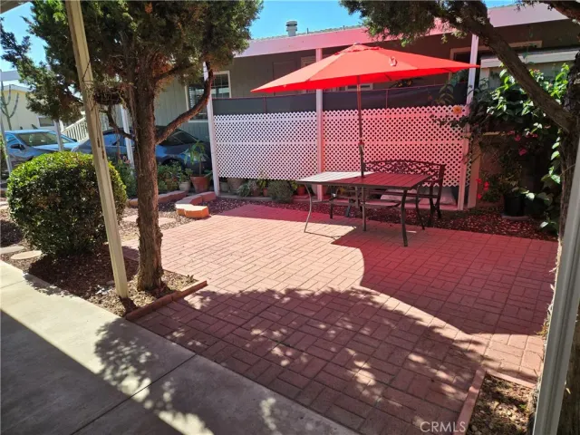 a patio with tables and chairs under an umbrella
