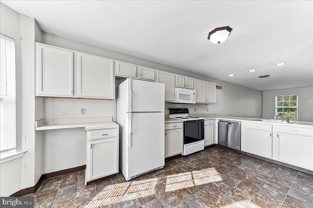103 Bonnybrook Road Middletown, DE 19709 - Photo 6 of 32 a kitchen with white cabinets and white appliances