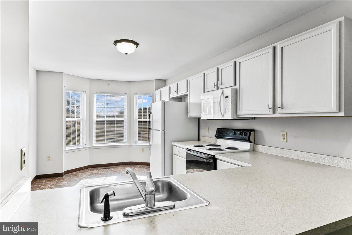 103 Bonnybrook Road Middletown, DE 19709 - Photo 10 of 32 a kitchen with stainless steel appliances granite countertop a sink stove and white cabinets with wooden floor