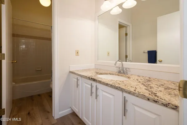 a bathroom with a granite countertop sink and a mirror