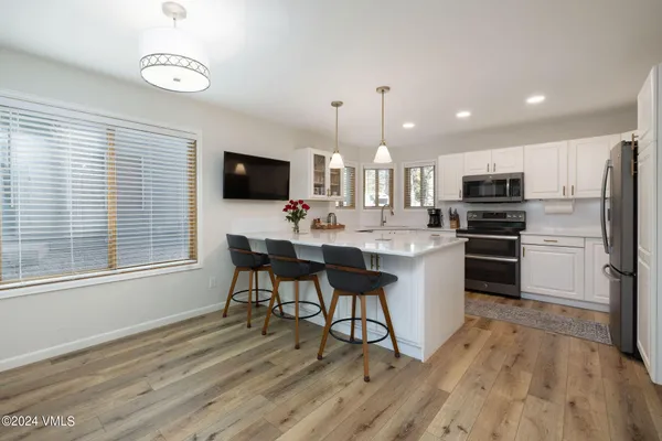 a kitchen with a sink stainless steel appliances and window