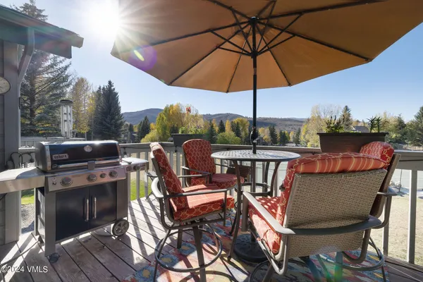a view of a roof deck with table and chairs under an umbrella