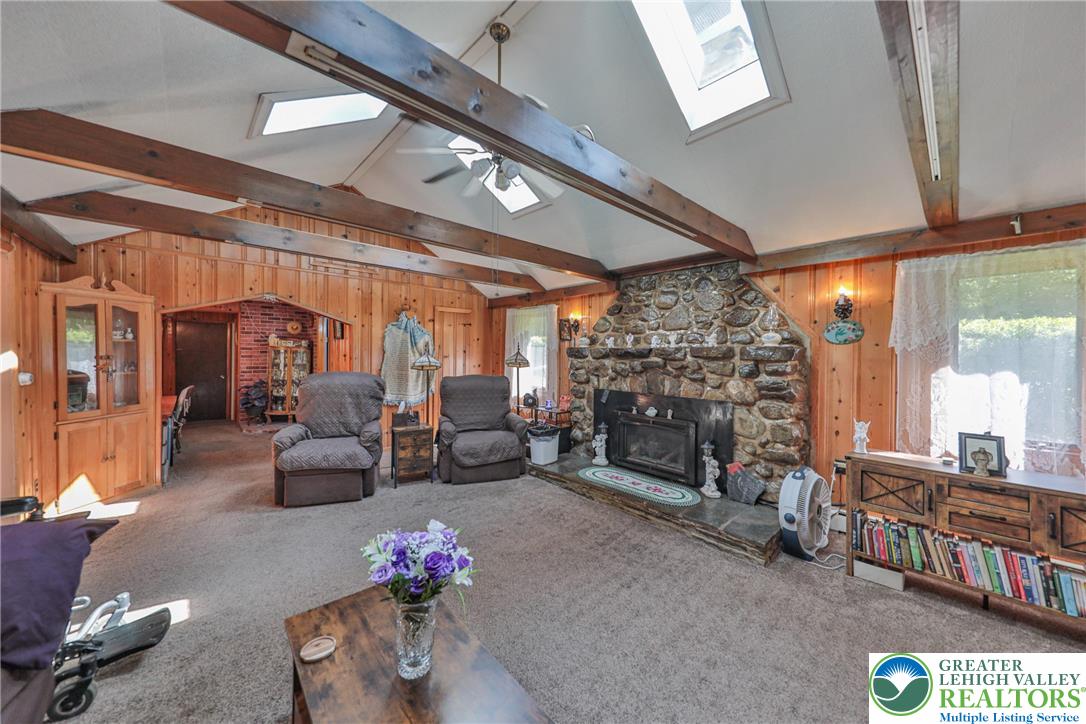 331 Cranberry Creek Road Cresco, PA 18326 - Photo 19 of 95 A stone fireplace anchors this inviting space, complemented by vaulted ceilings and natural wood paneling.