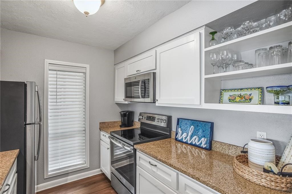 14300 Aloha Street, Unit 231 Corpus Christi, TX 78418 - Photo 8 of 37 a kitchen with stainless steel appliances granite countertop a sink stove and refrigerator