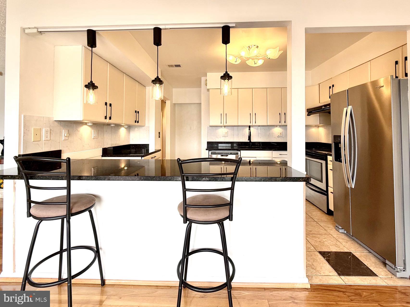 532 Riviera Drive, Unit 532B Joppa, MD 21085 - Photo 12 of 44 a kitchen with granite countertop a counter space chairs stainless steel appliances and cabinets