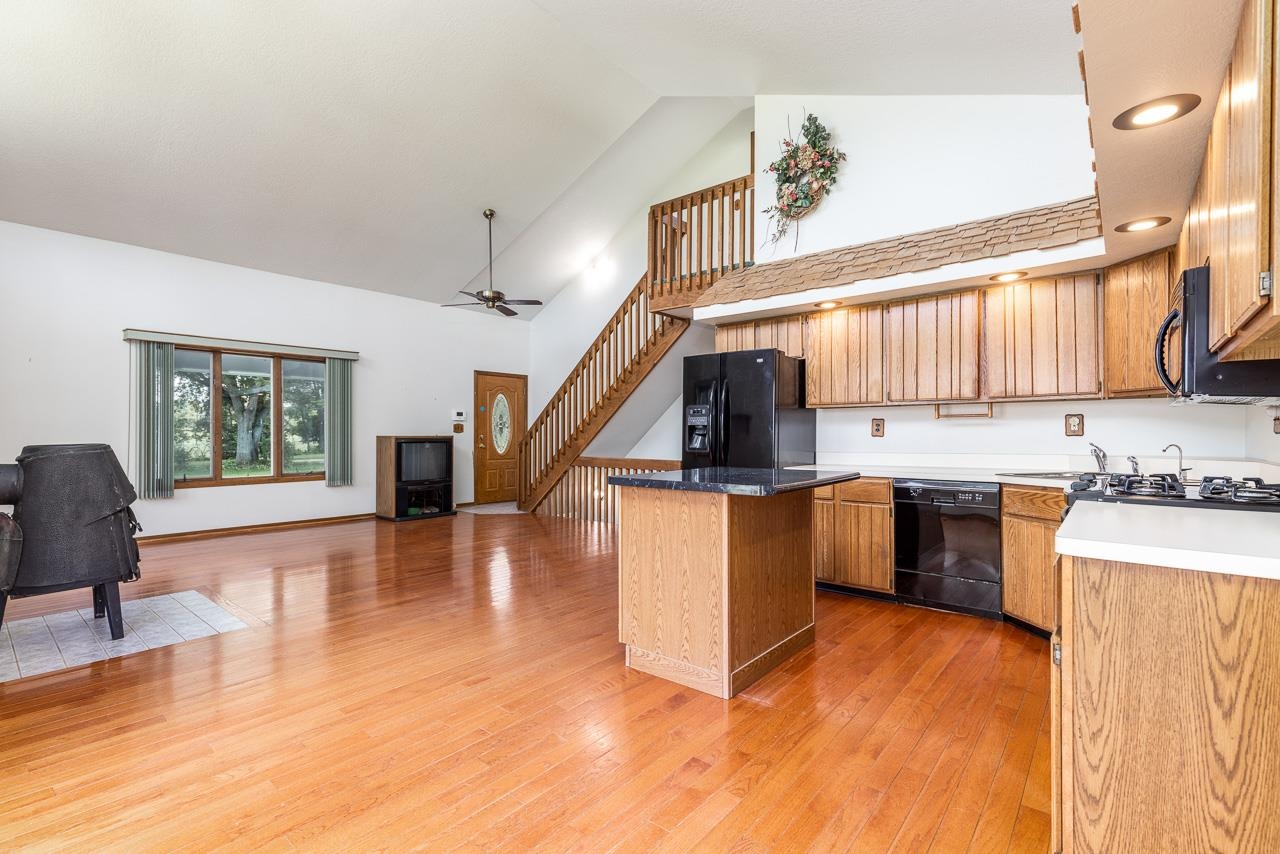 6418 Steward Road Rockford, IL 61101 - Photo 9 of 25 a kitchen with granite countertop a stove and a wooden floors