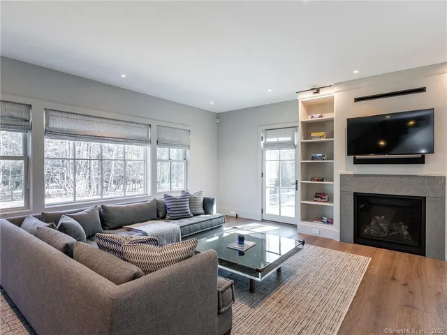 a living room with furniture a flat screen tv and a fireplace