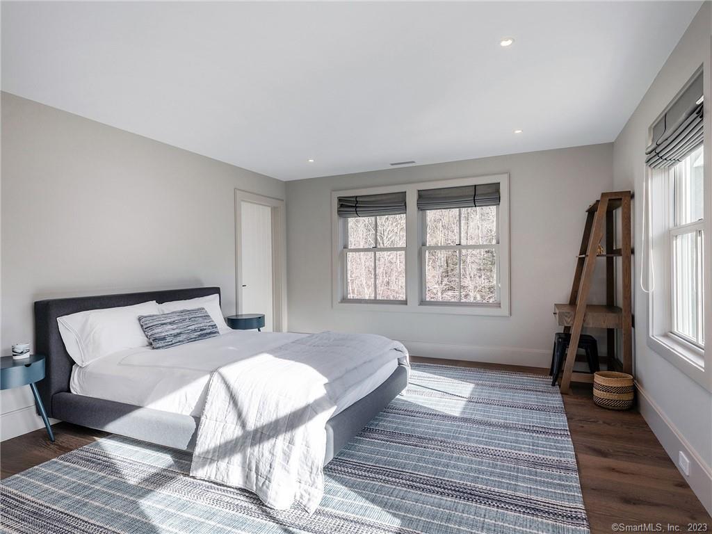 126 River Road Washington, CT 06794 - Photo 19 of 32 a bedroom with a bed and wooden floor