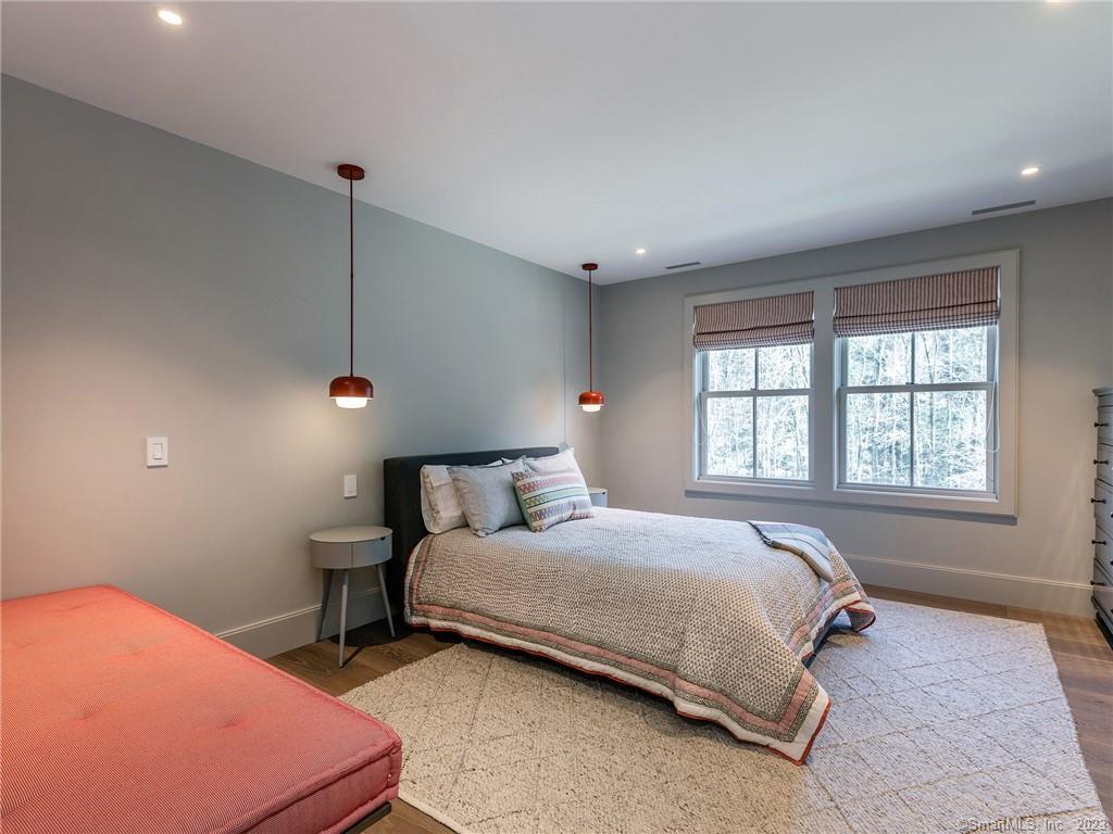 126 River Road Washington, CT 06794 - Photo 21 of 32 a bedroom with a bed a table and windows