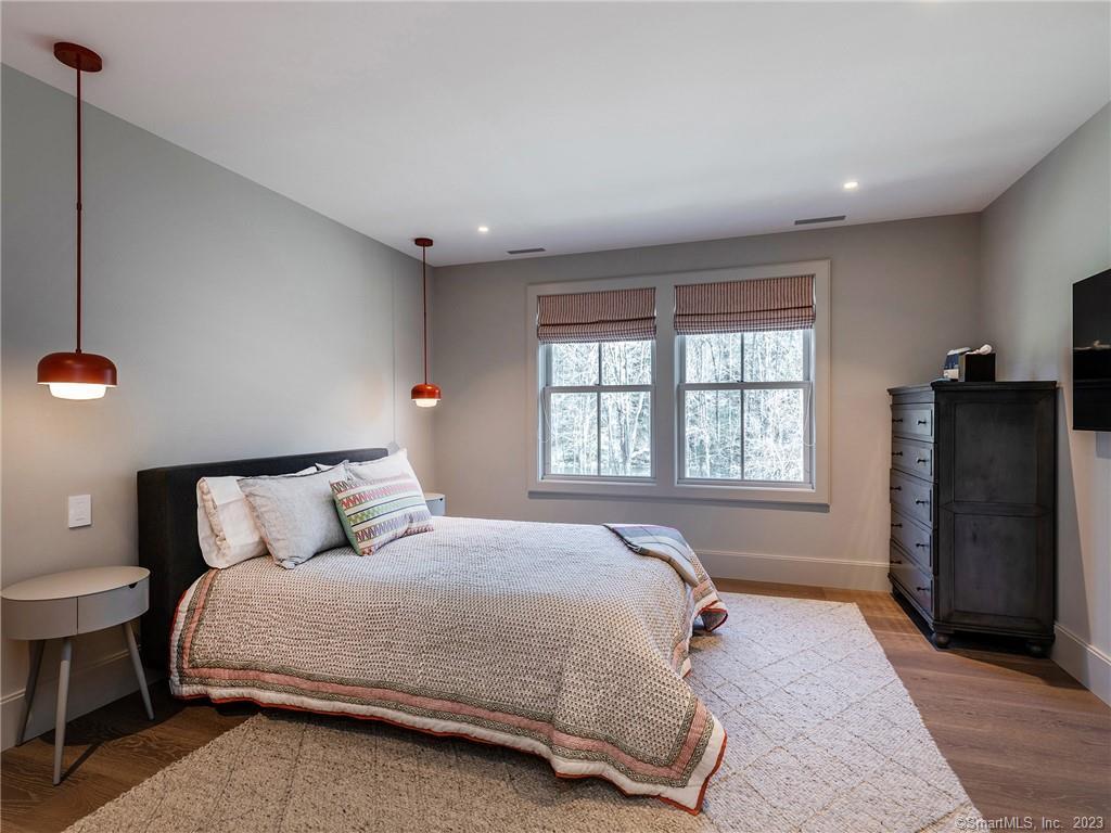 126 River Road Washington, CT 06794 - Photo 22 of 32 a bedroom with a bed and wooden floor
