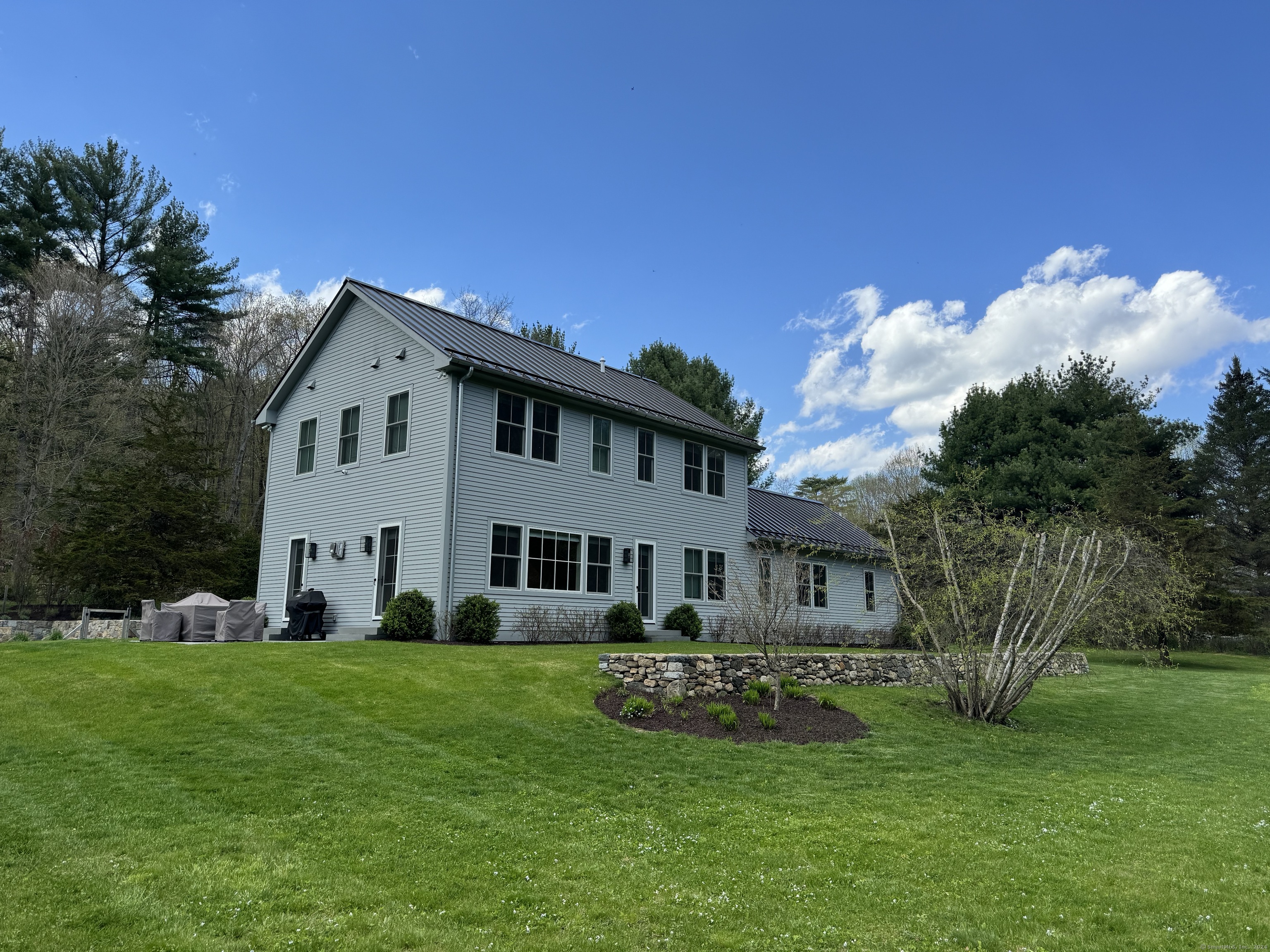 126 River Road Washington, CT 06794 - Photo 5 of 32 a front view of a house with a garden