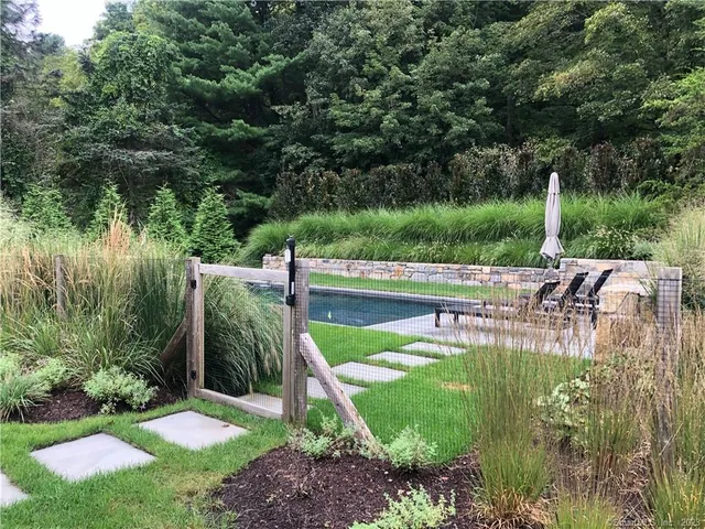 a view of backyard with swimming pool and seating space
