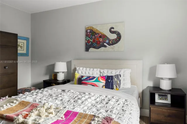 a bedroom with a bed and painting on the wall