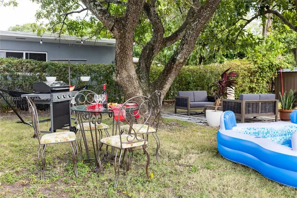 a view of a chairs and table in backyard of the house