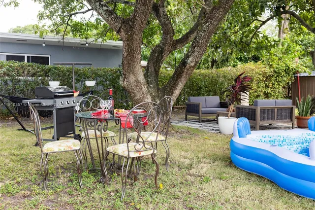 a view of a chairs and table in backyard of the house