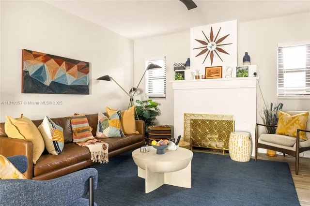 a living room with furniture a fireplace and a large window
