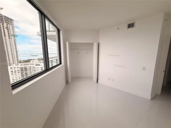 an empty room with windows and city view