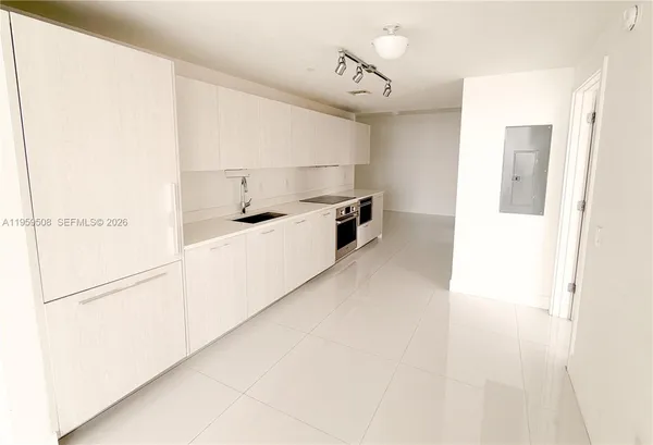 a kitchen with kitchen island a sink a stove and a refrigerator
