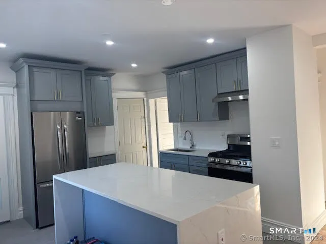 a kitchen with stainless steel appliances a refrigerator sink and stove