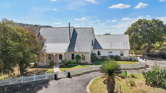a view of swimming pool with outdoor seating and house in the background