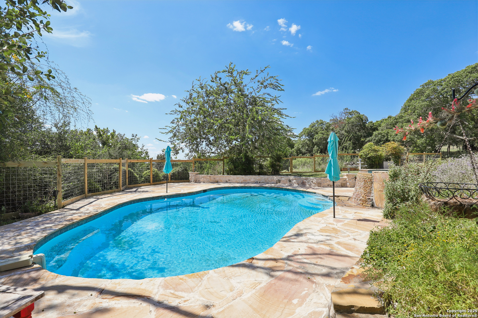 4380 Bear Springs Road Pipe Creek, TX 78063 - Photo 2 of 60 a view of a swimming pool with a yard and trees