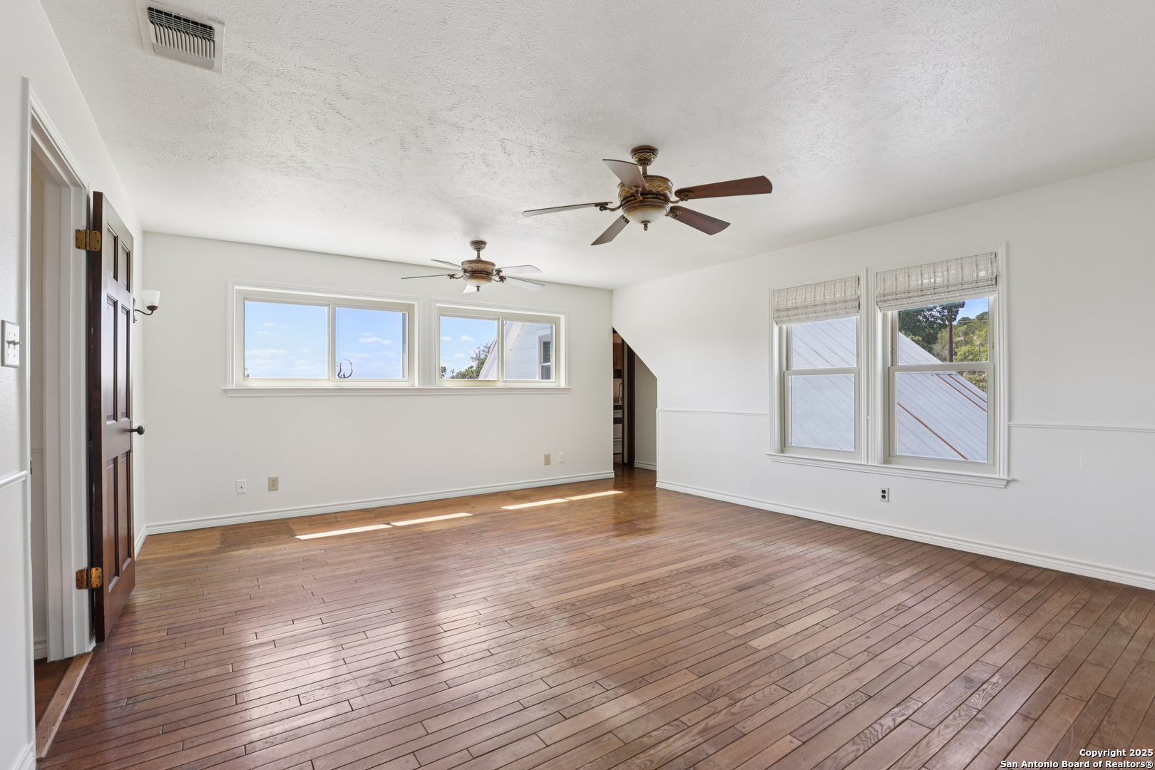4380 Bear Springs Road Pipe Creek, TX 78063 - Photo 24 of 60 a view of empty room with wooden floor and fan