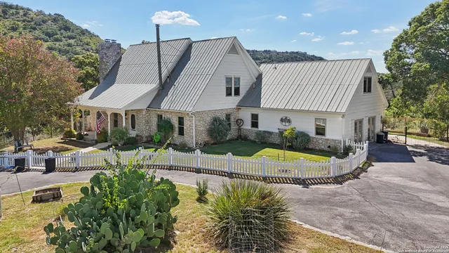 an aerial view of residential houses with outdoor space and trees