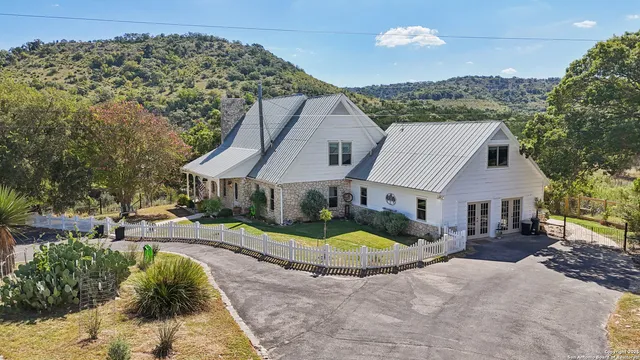 an aerial view of residential houses with outdoor space and trees